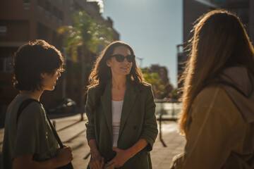 Fototapeta premium Women friends having urban conversation on city street