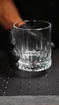 Barman presentando una elegante copa de c&oacute;ctel. Barman profesional mostrando una elegante copa de c&oacute;ctel. Servicio de bar de alta cocina, presentaci&oacute;n de c&oacute;cteles de primera calidad.
