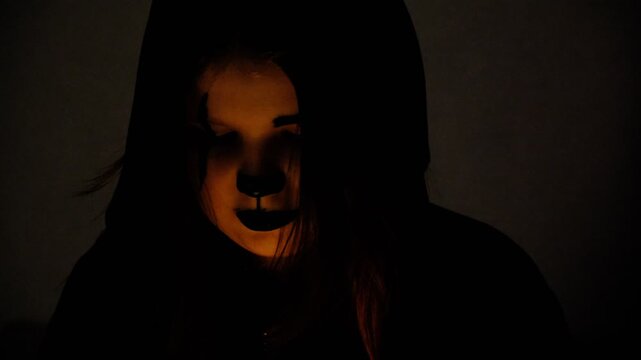 Make‑up on face girl, scary makeup, night, glowing LED blood coloring,  darkness , cinematic lighting, horror style. The dim night lighting enhances the eerie effect, casting shadows on her face.