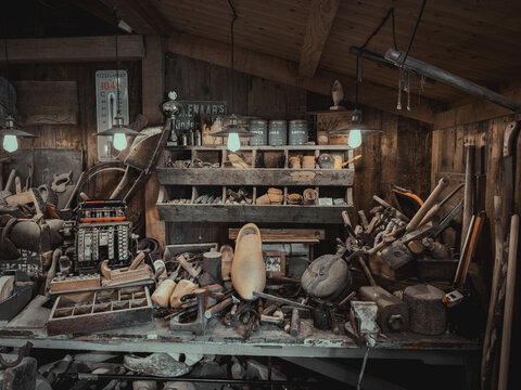 Traditional wooden clog on a messy workbench with vintage hand tools in a rustic Dutch artisan workshop