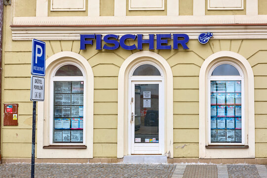 Travel agency fischer exterior with reserved parking sign on historic european street. March 15, 2026, Kolin, Czech Republic