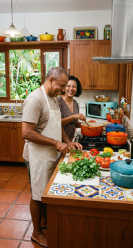 Middle-aged Brazilian mature couple cooking at home.