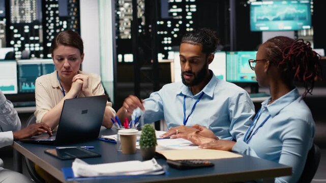 Multiethnic office coworkers reading emails on laptop in boardroom, ensuring project agenda. Cheerful employees analyzing data and KPIs on notebook, statistical information. Office life.