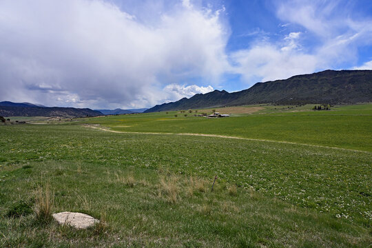 Much needed rain over agricultural fields of Grass Valley in Garfield County in western Colorado under developing storm clouds.