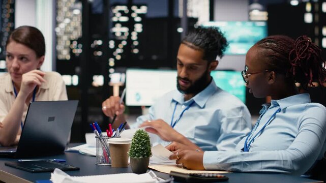 Office employees doing business meeting to plan project with reports, trying to meet objectives and deadline. Group of colleagues doing research and documenting forecast, action plan.