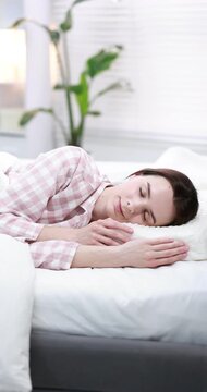 Woman lying on bed with orthopedic pillow at home