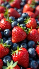 Obraz premium Close-up of ripe red strawberries and deep blue blueberries piled together. Berries show natural texture and green stems. Perfect for summer food content or health articles.