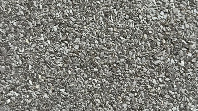 Close-up roof granules Uniflex waterproofing showing dense mineral granules embedded in dark asphalt membrane, high detail macro