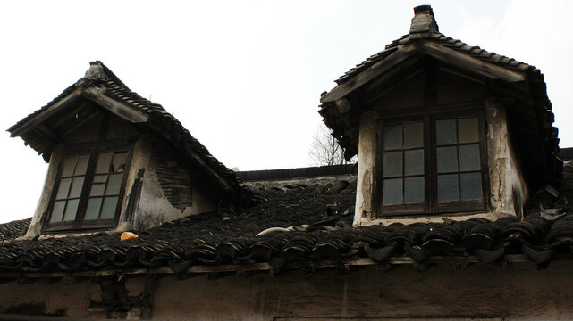 Traditional Chinese architecture dormer windows on a classic black tiled roof.