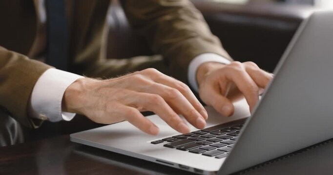 Businessman hands typing on laptop keyboard during remote work