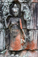 Fototapeta premium Ancient stone carving of a female deity, possibly at Angkor Wat, Siem Reap, Cambodia. The detailed bas-relief showcases traditional Khmer art and architecture. Preah Khan Temple