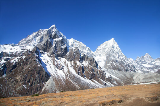 Majestic Himalayan mountains in Nepal with snow peaks and rocky terrain under a clear blue sky, showcasing the grandeur of nature in the Himalayas, ideal for adventure and travel enthusiasts.