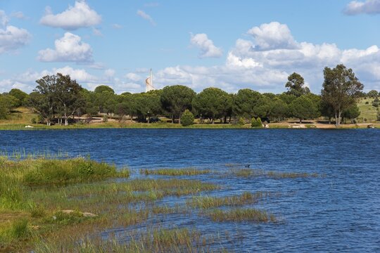 An idyllic lake with trees and blue water, framed by greenery and a sky with white clouds, reservoir, Proserpina dam, Presa romana de Proserpina, Embalse de Proserpina, Merida, Badajoz province, Extremadura, Spain