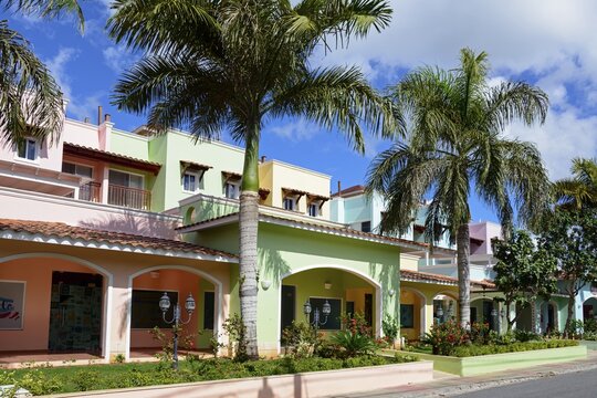 Colourful houses under a blue sky with palm trees create a tropical and relaxed atmosphere, Bayahibe, Dominican Republic, Hispaniola, Caribbean, America