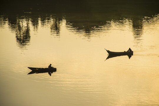 Fishermen in their canoes fishing at sunset on the Nile at Jinja source of the Nile, Uganda, Africa