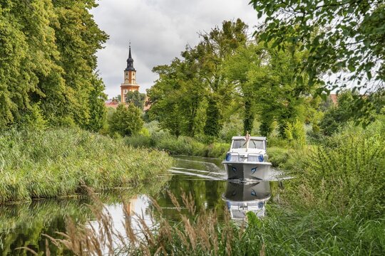 Motorboat on the Templin Canal, St. Mary Magdalene Church in the back, Templin, Uckermark, Brandenburg, Germany