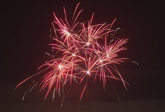 Red fireworks glow in vivid trails of light in the dark, Lower Saxony, Germany