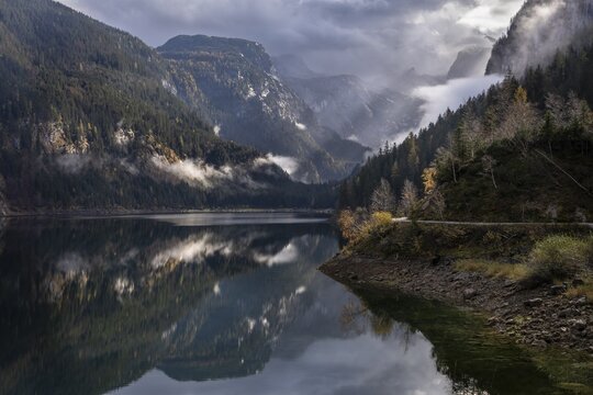 The Vordere Gosausee in autumn. In the background, the Dachstein mountain range in clouds. Cloudy sky. A few rays of sunshine. Vorderer Gosausee, Gosau, Gosau Valley, Salzkammergut, Upper Austria, Austria