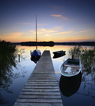 Quiet lake with jetty and boats after sunset at dusk, Gro&szlig;er Lychensee, Lychen, Brandenburg, Germany