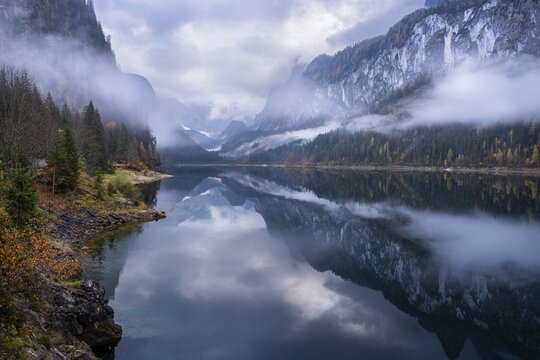 The Vordere Gosausee in autumn with a view of the Gosaukamm on the right. The Dachstein in clouds in the background. Cloudy sky. Overcast. Reflection. Vorderer Gosausee, Gosau, Gosau valley, Salzkammergut, Upper Austria, Austria