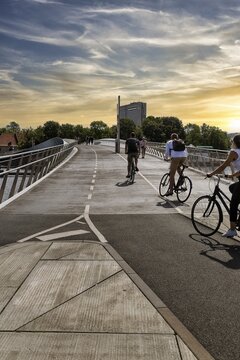 Pedestrians and cyclists on bridge over Inner Harbour, Lille Langebro cycle bridge, road safety, modern mobility, architects WilkinsonEyre and BuroHappold, backlight, sunset, city centre, Copenhagen, Denmark