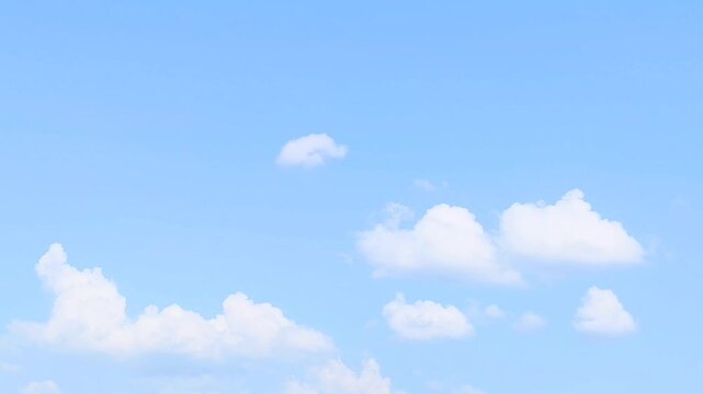 Beautiful bright blue sky with soft white fluffy clouds in a sunny day natural background for creative design