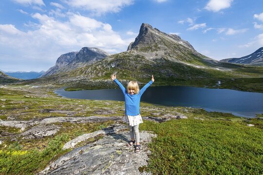 Little girl enjoying the view over a glacial valley, Trollstigen mountain road, Norway