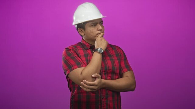Man in white hardhat and red plaid shirt with hand on chin and folded arm in studio, engineer; thoughtful reflection.