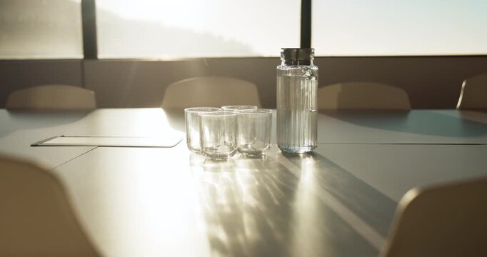 Meeting, window and water on tablet in empty office for workshop, corporate and boardroom. Business, conference and furniture with h2o drink on desk of interior room for seminar and workspace