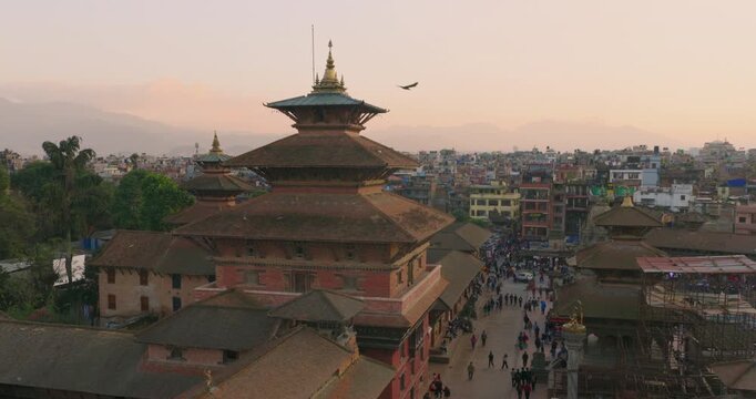 Aerial view of Patan Durbar Square with historic pagoda temples, Newari palace buildings, evening visitors and warm sunset atmosphere in Lalitpur, Nepal.