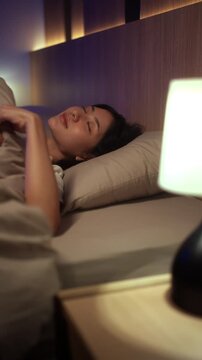 Young woman sleeping peacefully in comfortable bed at home. Sleep well, sweet dreams, deep sleep, relaxation, healthy lifestyle, wellness and bedtime comfort concept.
