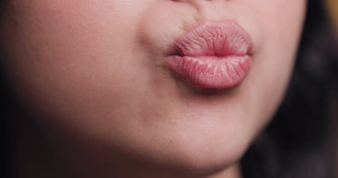 Close-up of a woman's puckered lips, highlighting detailed skin texture
