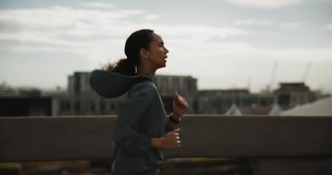 Running, fitness and woman in city for cardio health, wellness and endurance training. Athlete, jog and person in urban town for sports, exercise and runner practice on bridge for workout outdoor