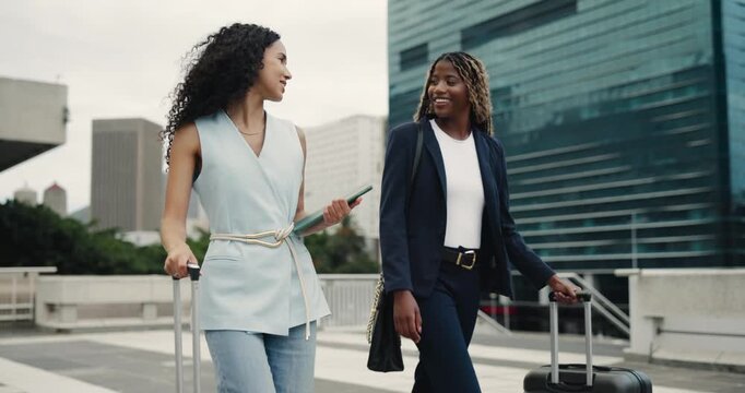 Happy women, business travel and walking with suitcase in city for work trip or commute together. Female people, employee or colleagues with smile, tablet or luggage for new career or job opportunity