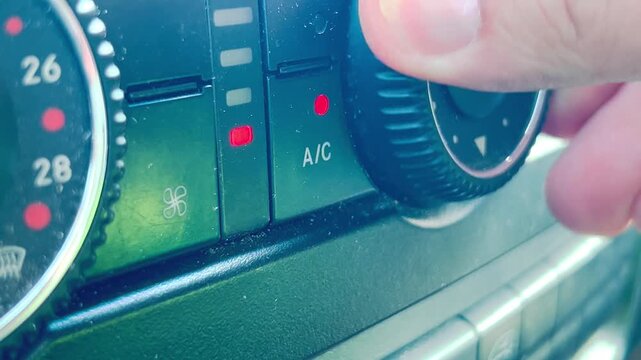 Ein Mann stellt in seinem Auto die Klimaanlage ein