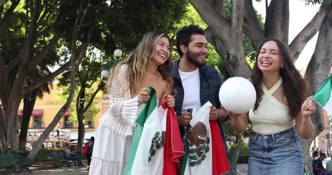group of mexican soccer fans holding a soccer ball and national flag supporting to their sport team outdoors in Mexico city in Latin America
