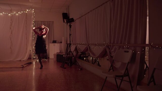 Sexy retro woman with fancy vintage hairstyle dancing in low-light hall. Elegant classic dance movements with cheerful expressive energy. Nostalgic style performance captured in high quality 4K.