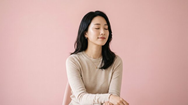 A young Asian woman smiling peacefully.