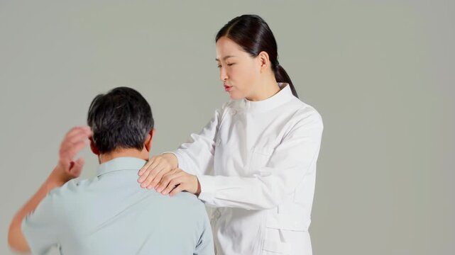 Young woman hand massagist orthopedic specialist doctor check, examing and doing massage physiotherapy to treat old patient shoulder back, neck, spine at physical therapy checkup, doing stretching