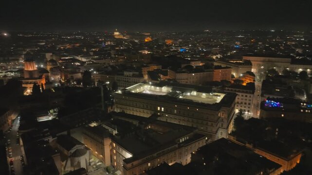 Night drone shot over Rome, capturing the illuminated Palazzo Koch (Bank of Italy) and cityscape
