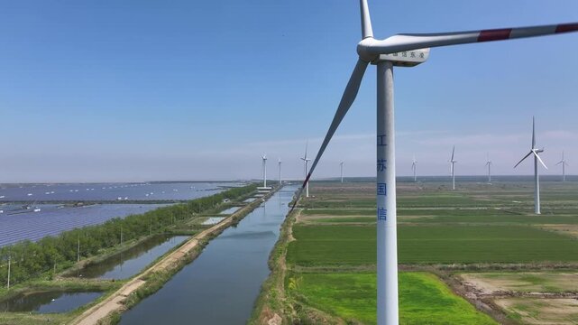 Wind turbines and solar panels coexist in a green energy landscape with river and fields
