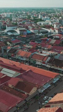 Aerial view of the bustling Psar Chaa (Old Market) area in Siem Reap, Cambodia, showcasing traditional architecture and vibrant street life with traffic and pedestrians.