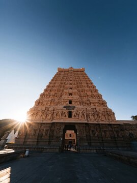 Ancient dravidian gopuram temple tower with intricate sculptures and golden hour sunlight for travel brochures, cultural heritage documentation and religious tourism
