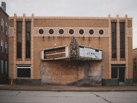 Front view of the abandoned historic Art Deco Massac Theatre building with a boarded up plywood entrance in Metropolis Illinois