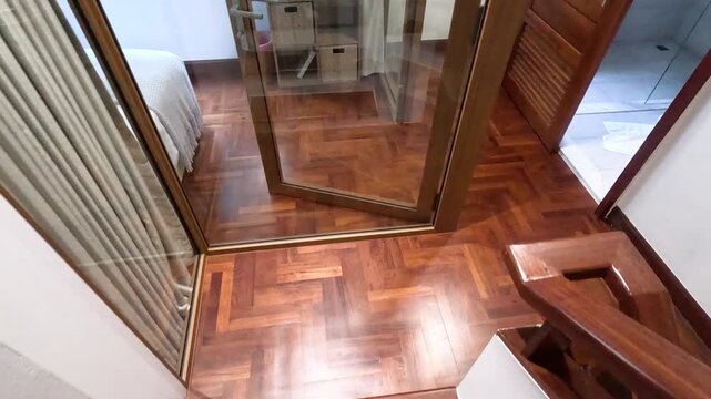 Descending Wooden Stairs with Parallax View of Herringbone Hardwood Flooring
