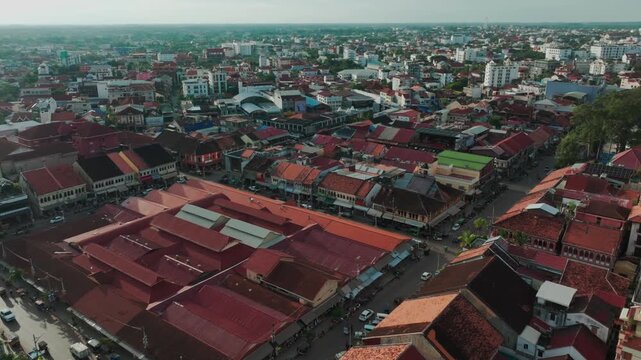 Aerial view of the bustling Psar Chaa (Old Market) area in Siem Reap, Cambodia, showcasing traditional architecture and vibrant street life with traffic and pedestrians.