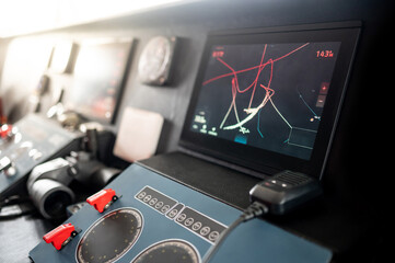 Digital GPS navigation monitor screen with VHF Radio, marine radar system and binoculars on modern boat dashboard in wheelhouse or ship captain bridge. Nautical vessel technology © zephyr_p