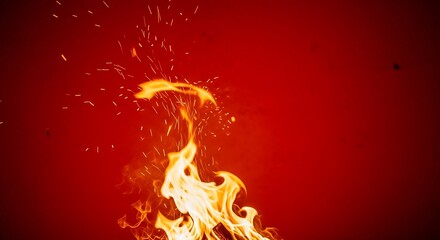 Fototapeta premium Bright orange fire flames with flying sparks over red background