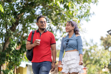 Naklejka premium Young Couple Walking Together in Residential Neighborhood