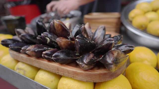 Chef prepares mussels and lemons at local market in summer